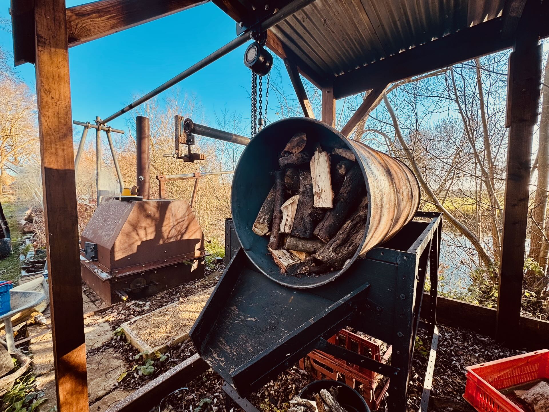 A drum loaded with locally-sourced timber, ready to char in the retort beside the river